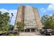 Modern high-rise building featuring a mix of brick and white concrete, mature trees, and ample parking at 215 Piedmont Ne Ave # 507, Atlanta, GA 30308