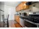 Efficient kitchen with wood cabinetry, modern appliances, tile backsplash, and durable hardwood flooring for easy maintenance at 215 Piedmont Ne Ave # 507, Atlanta, GA 30308