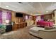 Spacious carpeted bedroom with wood paneled walls, TV, dresser, and sitting area at 2255 Chippewa Dr, Riverdale, GA 30296