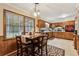 The kitchen has wood cabinets, a black dishwasher, a dining table, and tile floors and is lit by a pendant light at 2255 Chippewa Dr, Riverdale, GA 30296