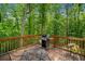 Outdoor deck with gas grill and seating area, surrounded by trees at 500 Nolan Rd, Carrollton, GA 30116