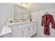 Bright bathroom with marble countertop vanity, robe hanging on hook, and soft, natural light at , Buford, GA 30518