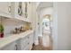 Butler's pantry features white cabinetry with gold hardware and marble countertops at , Buford, GA 30518