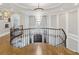 Elegant hallway with hardwood floors, white walls, and a tiered chandelier at , Buford, GA 30518