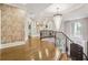 Bright hallway with hardwood floors, decorative wallpaper, and a modern chandelier at , Buford, GA 30518