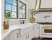 Bright kitchen with white cabinets, farmhouse sink, quartz countertops, and stainless steel appliances at , Buford, GA 30518
