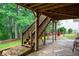 Backyard with a stone patio, wooden staircase, and wooded scenery at 138 Knightwood Pt, Acworth, GA 30101