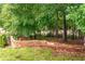Serene backyard featuring a stone retaining wall, mature trees, and lush greenery creating a private oasis at 138 Knightwood Pt, Acworth, GA 30101