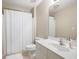Clean bathroom featuring a shower, toilet, tile flooring, a white vanity, and a large mirror at 138 Knightwood Pt, Acworth, GA 30101