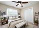 Staged bedroom with modern decor, neutral colors, bench, and large window view at 138 Knightwood Pt, Acworth, GA 30101