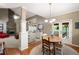 Open-concept dining area with a chandelier, access to the deck, and view of stone fireplace at 138 Knightwood Pt, Acworth, GA 30101
