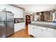 Well-appointed kitchen with stainless steel refrigerator, white cabinets, and granite countertops overlooking the living area at 138 Knightwood Pt, Acworth, GA 30101