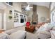 Bright living room with built-in shelving, a stone fireplace, neutral decor, and comfortable seating arrangement at 138 Knightwood Pt, Acworth, GA 30101