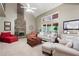 Comfortable living room featuring a stone fireplace, vaulted ceiling, neutral colors, and large windows overlooking nature at 138 Knightwood Pt, Acworth, GA 30101