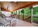 Inviting screened porch with wood ceiling, cozy seating, and peaceful views of the surrounding greenery at 138 Knightwood Pt, Acworth, GA 30101