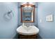 Powder room featuring a pedestal sink and decorative mirror at 1769 Milford Creek Sw Cts, Marietta, GA 30008