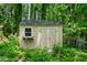 Backyard shed with neutral siding is framed by vibrant green foliage and sturdy fencing at 1769 Milford Creek Sw Cts, Marietta, GA 30008