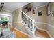 A well-lit staircase with white railings and carpeted steps leads to the upper level of the home at 1769 Milford Creek Sw Cts, Marietta, GA 30008