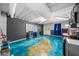 Finished basement with blue epoxy floor, kitchenette, and doorway to the exterior of the home at 1887 Chedworth Ct, Stone Mountain, GA 30087