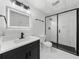 Contemporary bathroom featuring black fixtures, marble-look shower, and illuminated mirror over vanity at 1887 Chedworth Ct, Stone Mountain, GA 30087