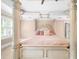 Close-up of an elegant four-poster bed with pink accents and a ceiling fan at 1887 Chedworth Ct, Stone Mountain, GA 30087