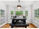 Dining room features wood floors, bay windows overlooking backyard, and modern chandelier at 1887 Chedworth Ct, Stone Mountain, GA 30087