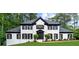 Elegant two-story white brick home with black trim, shutters, and lush landscaping at 1887 Chedworth Ct, Stone Mountain, GA 30087