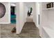 Hallway with neutral tile floors leading to a recreational space with blue epoxy floor and other rooms at 1887 Chedworth Ct, Stone Mountain, GA 30087