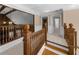 Upstairs hallway featuring wooden railing, neutral paint, carpet and high ceilings at 1887 Chedworth Ct, Stone Mountain, GA 30087
