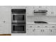 Stainless steel double oven is set in modern kitchen with white cabinets and countertops at 1887 Chedworth Ct, Stone Mountain, GA 30087