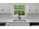 A kitchen sink features matte black faucet set under a window with view of the garden at 1887 Chedworth Ct, Stone Mountain, GA 30087