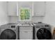 Bright laundry room with front load washer and dryer set under a window at 1887 Chedworth Ct, Stone Mountain, GA 30087