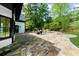 Spacious stone patio with outdoor seating area surrounded by lush greenery at 1887 Chedworth Ct, Stone Mountain, GA 30087
