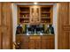Cozy wet bar area with wood cabinets, granite countertops, and glass shelving at 1887 Chedworth Ct, Stone Mountain, GA 30087