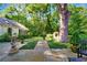 Flagstone backyard patio with mature landscaping, boxwoods, and white garden archway for lovely outdoor living at 3382 Habersham Rd, Atlanta, GA 30305
