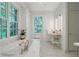 Bright bathroom featuring white marble finishes, a luxurious soaking tub, and views of the private yard at 3382 Habersham Rd, Atlanta, GA 30305