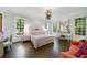 Bright main bedroom with large windows, dark wood floors, and a decorative floral arrangement hanging from the ceiling at 3382 Habersham Rd, Atlanta, GA 30305