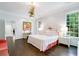 Bright main bedroom with white walls, dark wood floors, and desk with decorative painting above at 3382 Habersham Rd, Atlanta, GA 30305