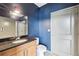 Modern bathroom boasts granite countertop, ample cabinet space, blue accent wall, and tiled shower at 3400 Malone Dr # 303, Atlanta, GA 30341