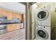 Convenient laundry area with stacked washer and dryer, situated near the kitchen with wood cabinets at 3400 Malone Dr # 303, Atlanta, GA 30341