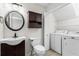 Bathroom featuring a sink and toilet with a cabinet, plus a laundry area with machines at 4108 Gray Birch Ln, Duluth, GA 30096