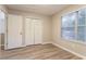 Bright bedroom with hardwood floors, a window with blinds, and a closet at 7113 Ambercrest Ct, Austell, GA 30168