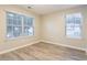Sunlit bedroom featuring hardwood floors and two large windows at 7113 Ambercrest Ct, Austell, GA 30168