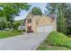 The lovely yellow two-story home features a spacious driveway and an attached two-car garage at 7113 Ambercrest Ct, Austell, GA 30168