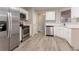 Modern kitchen featuring stainless steel appliances, white cabinets, and durable light gray flooring at 7113 Ambercrest Ct, Austell, GA 30168