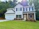 Charming two-story home features a well-manicured lawn, stone accents and a two car garage at 16 Deer Place, Villa Rica, GA 30180