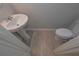 Compact powder room features a pedestal sink, toilet, and stylish flooring, maximizing space efficiency at 16 Deer Place, Villa Rica, GA 30180