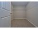 Empty walk-in closet featuring white shelving and neutral carpeting at 16 Deer Place, Villa Rica, GA 30180