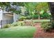 Picturesque backyard with artificial turf, a stone retaining wall, and manicured landscaping at 1974 Mason Mill Rd, Decatur, GA 30033