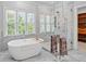 This primary bathroom showcases a soaking tub next to a glass shower with marble tile and a walk-in closet at 1974 Mason Mill Rd, Decatur, GA 30033